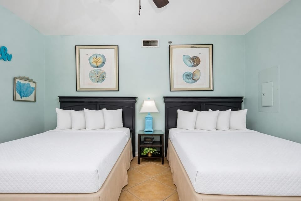 The artwork complements two double beds, creating a refreshing and inviting atmosphere in this guest room