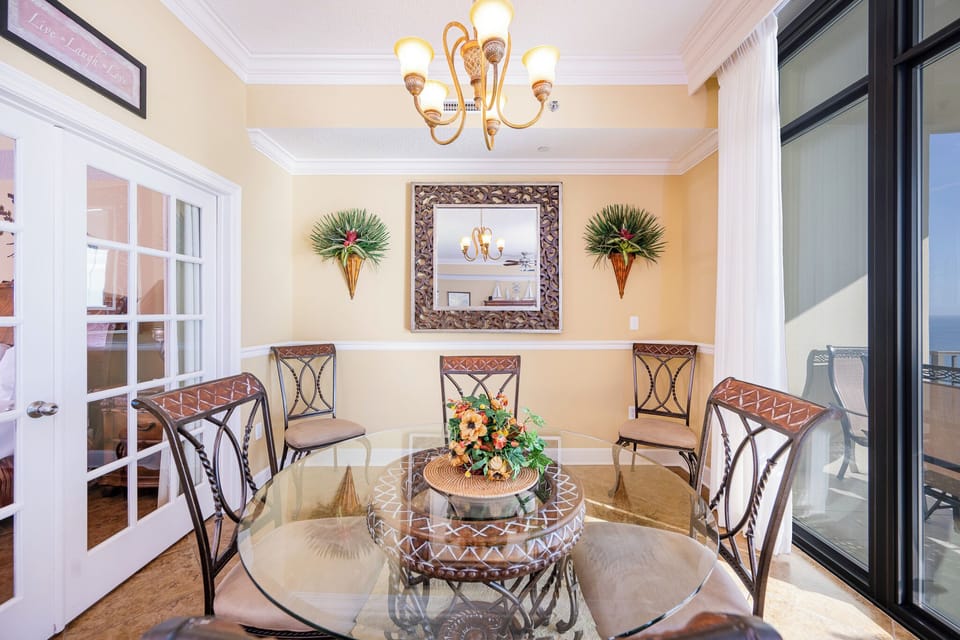 Gather around the glass dining table, delighting in laughter and fresh coastal breezes from your balcony