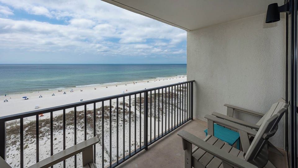 Enjoy a breathtaking beachfront view from the balcony, complete with comfortable seating for relaxation