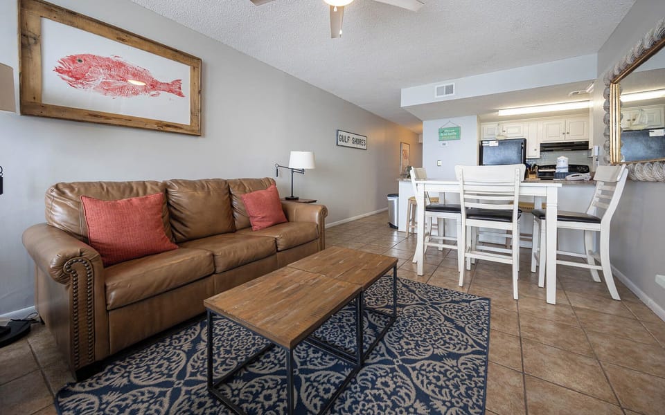The living area features a cozy leather sofa, a rustic coffee table, and a dining set, perfect for relaxation and meals