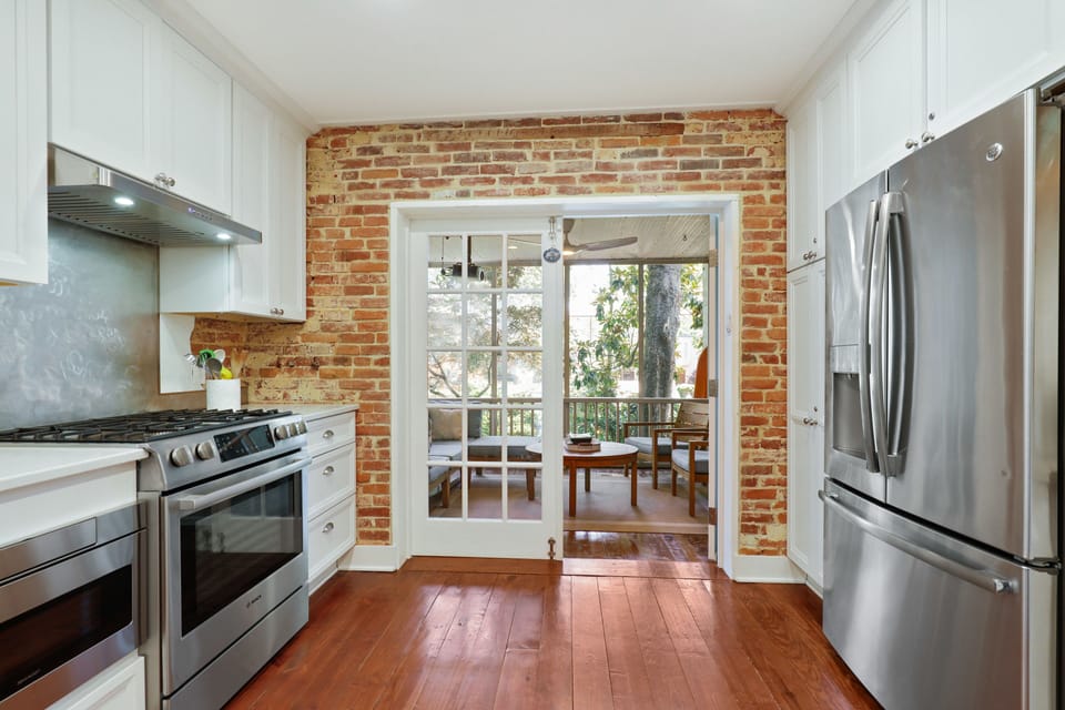 From kitchen to screened porch overlooking the brick walled garden.