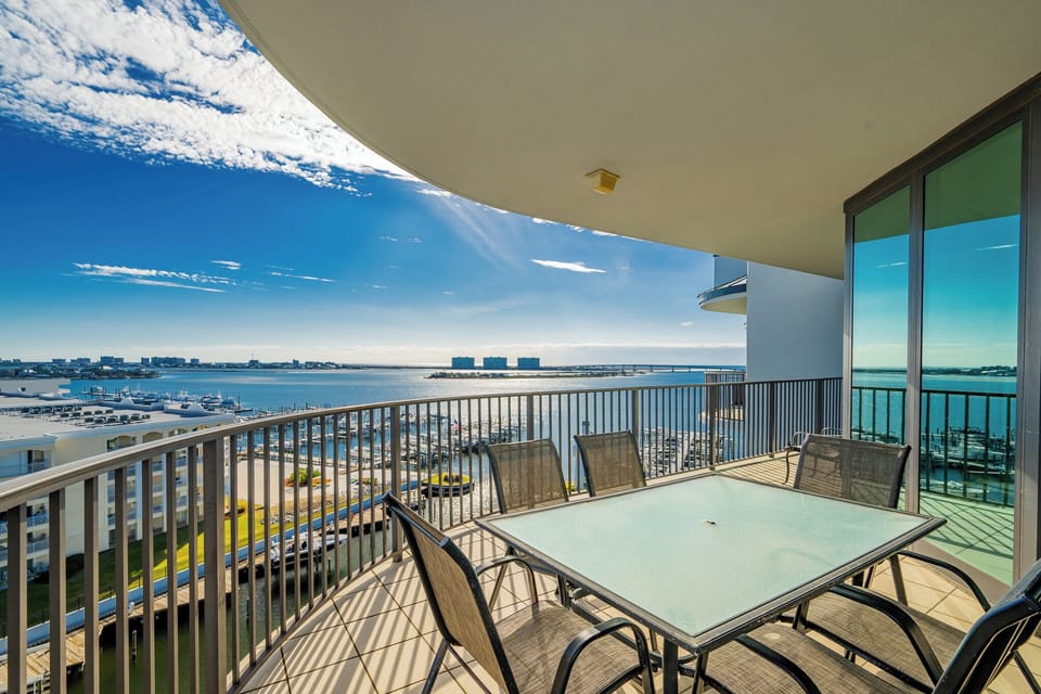 Enjoy stunning bay views of the marina from the spacious balcony with a glass-top table and comfortable seating