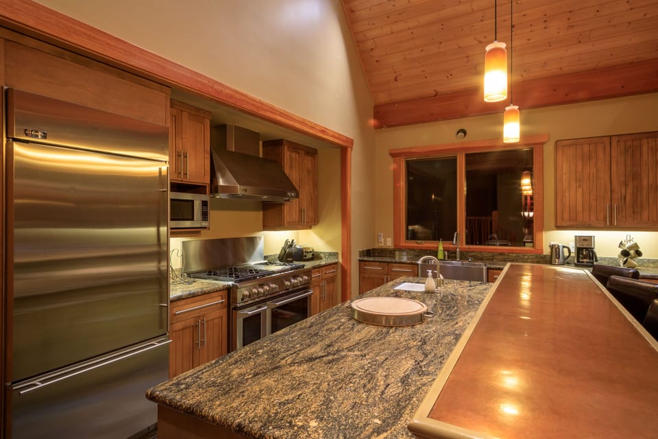 Modern gourmet kitchen with granite countertops, 6 burner range with vent hood,