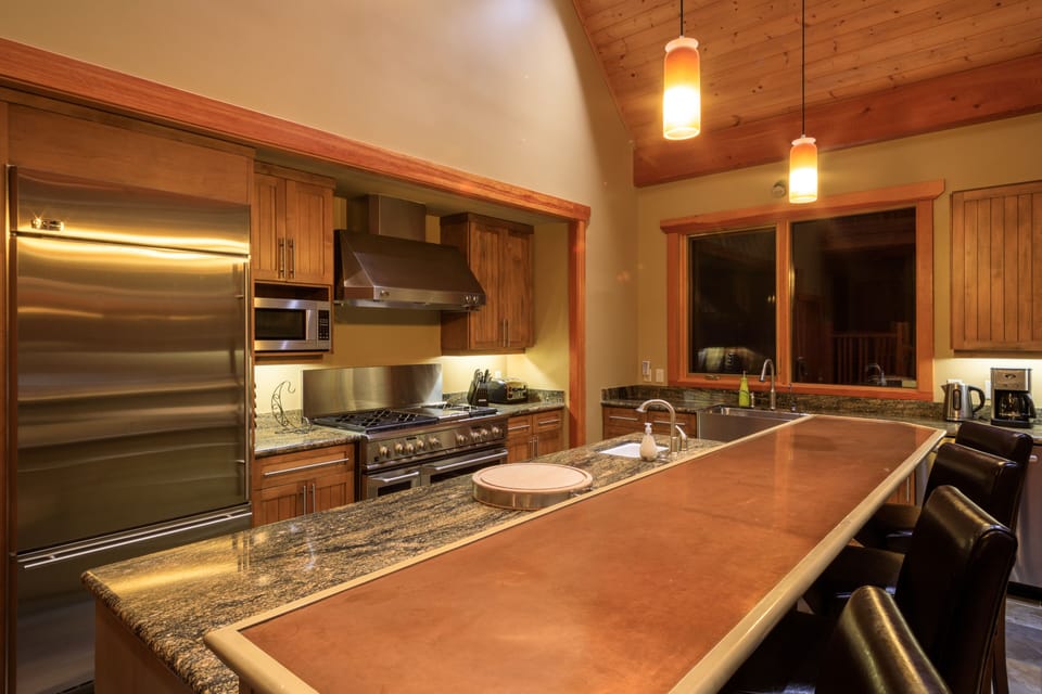 side by side fridge, microwave, dishwasher and sit-up bar with seating for four.