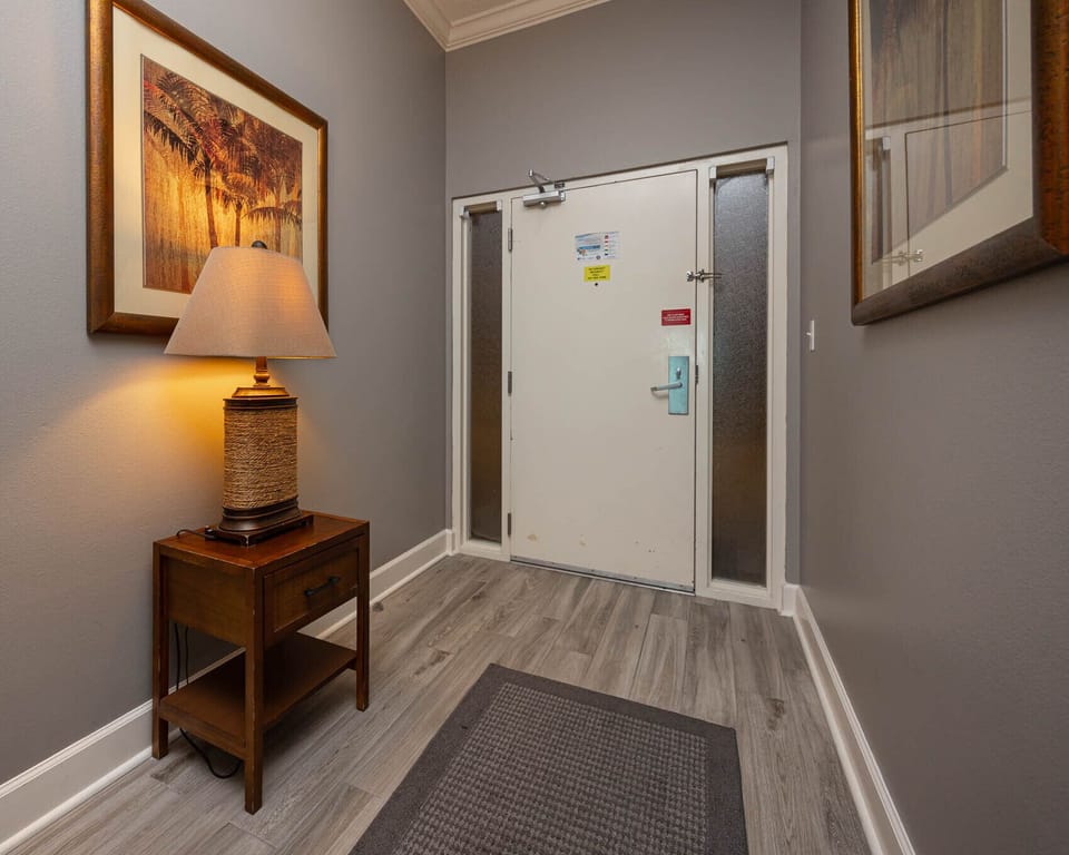 Step into your calming entrance, where warm lighting welcomes you to your beach retreat, setting the perfect vacation vibe