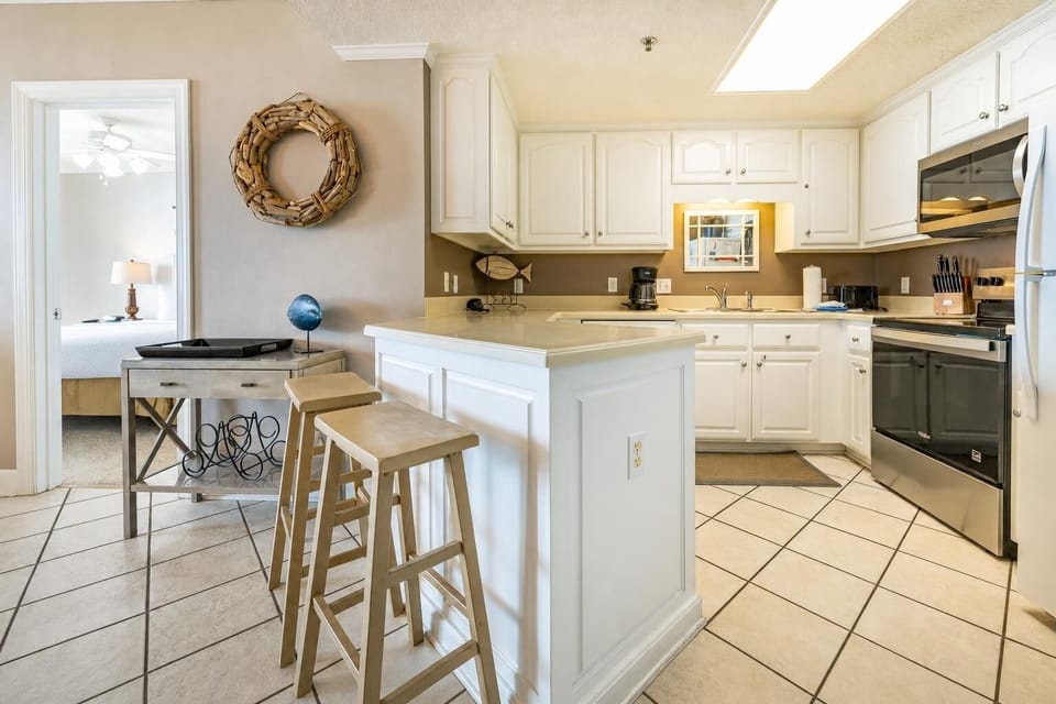 Soft tile cools underfoot as you prepare fresh meals at the breakfast bar in the cozy kitchen