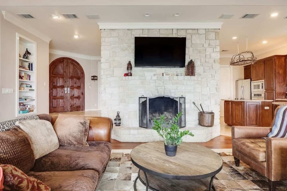 The living room boasts comfortable Texas-themed furnishings, a 70-inch flat-screen TV, and huge windows with an impressive view of the lake.