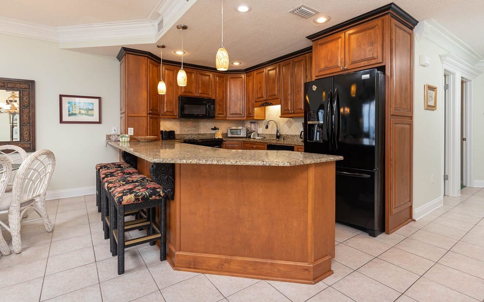 Warm wood cabinetry complements the granite countertops in this inviting kitchen area, featuring bar seating