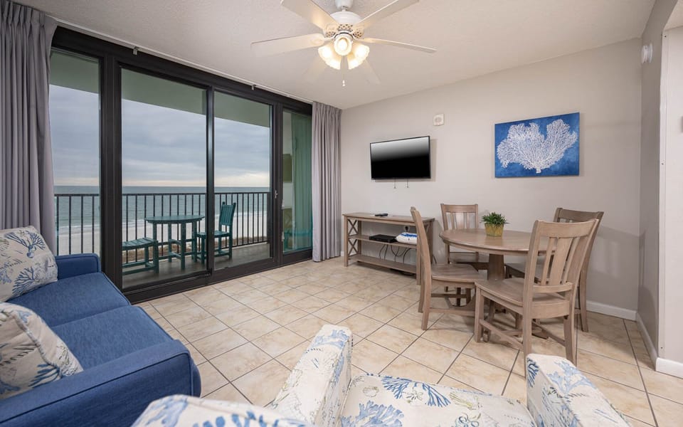 Relax in the inviting living area with comfortable seating and a mounted TV and enjoy views of the beach from the balcony
