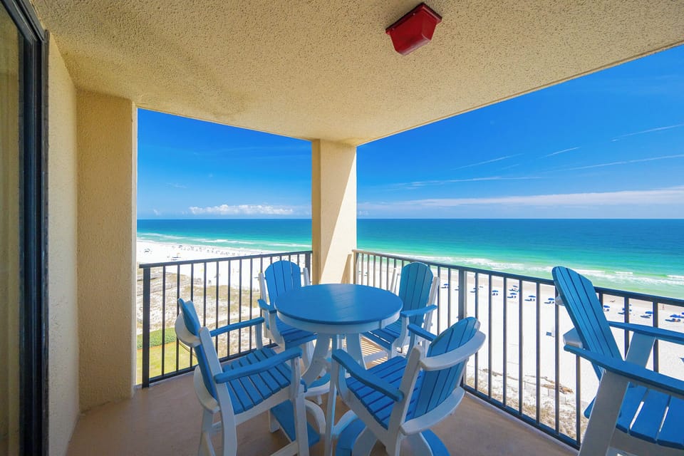 Your balcony invites you to savor the gulf breeze while sharing stories around a sunny blue table