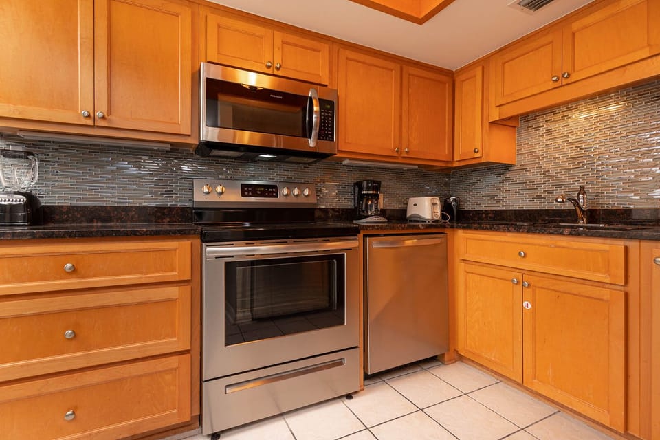 This kitchen features stainless appliances, granite countertops, and a coffee maker for a delightful cooking experience