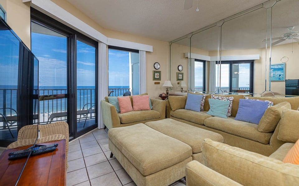 Cozy living area features a large sectional sofa with queen sleeper, offering views of the gulf through expansive windows