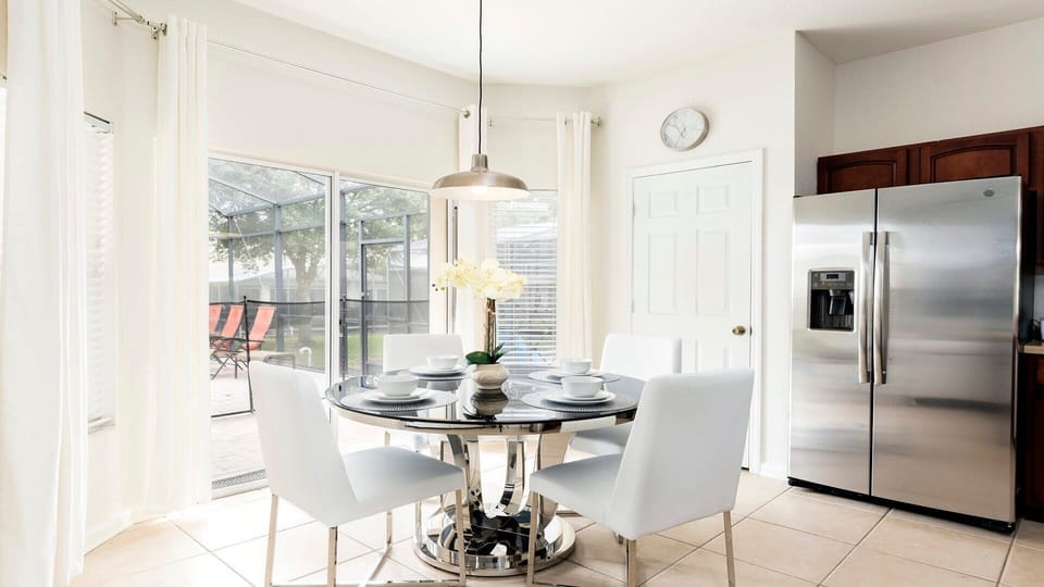 Modern, bright kitchen with stylish dining, stainless steel fridge, and patio access!