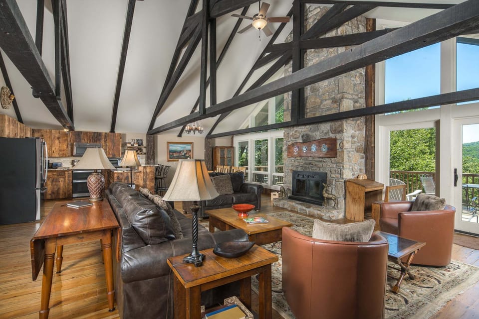 The open living area offers comfortable seating, a wood-burning fireplace, and beautiful mountain views