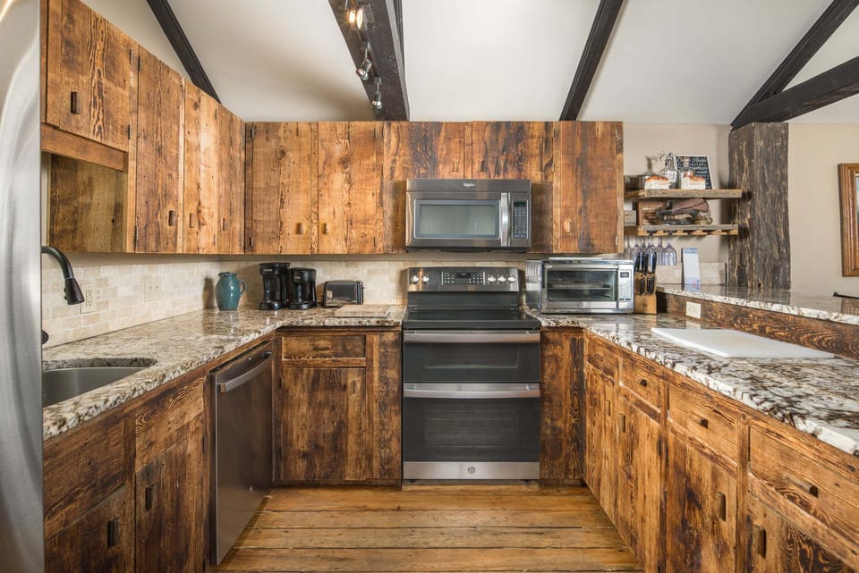The fully equipped kitchen features stainless steel appliances and quartz countertops