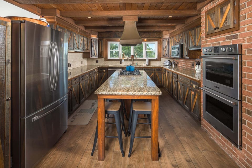 Fully equipped chef's kitchen with granite countertops, a large island, and modern appliances