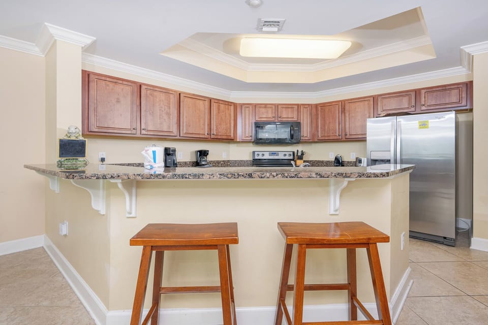 Modern kitchen with granite countertops, stainless appliances, and cozy bar seating for a welcoming dining experience