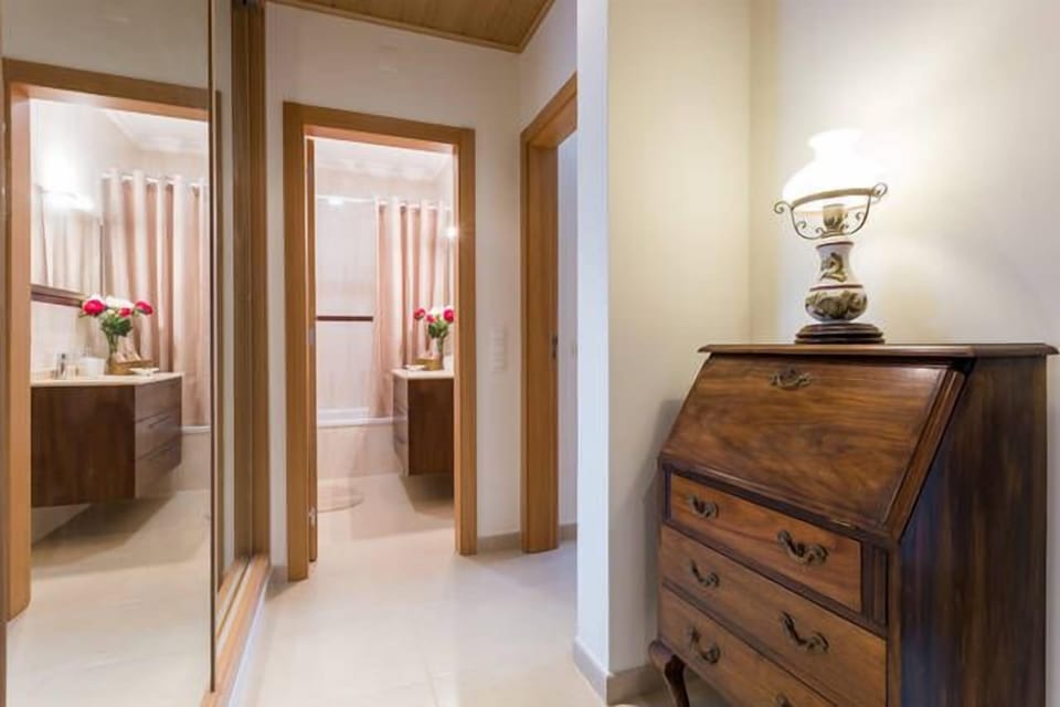 View of bathroom from hallway with full length mirrored cupboards