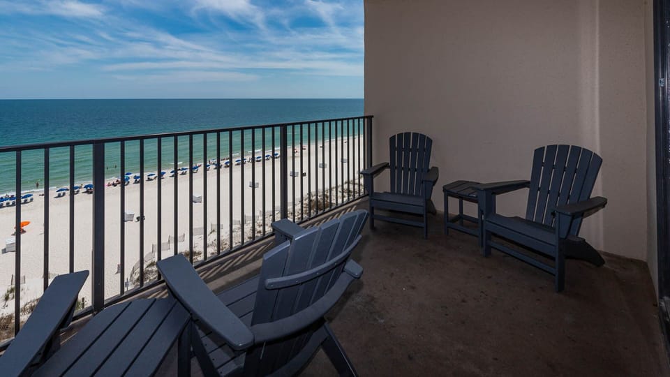 Relax in comfortable chairs on the balcony while enjoying views of the beach and gentle waves below