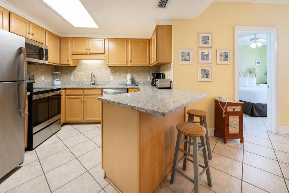 Granite breakfast bar invites casual chats while you prepare fresh meals in the kitchen