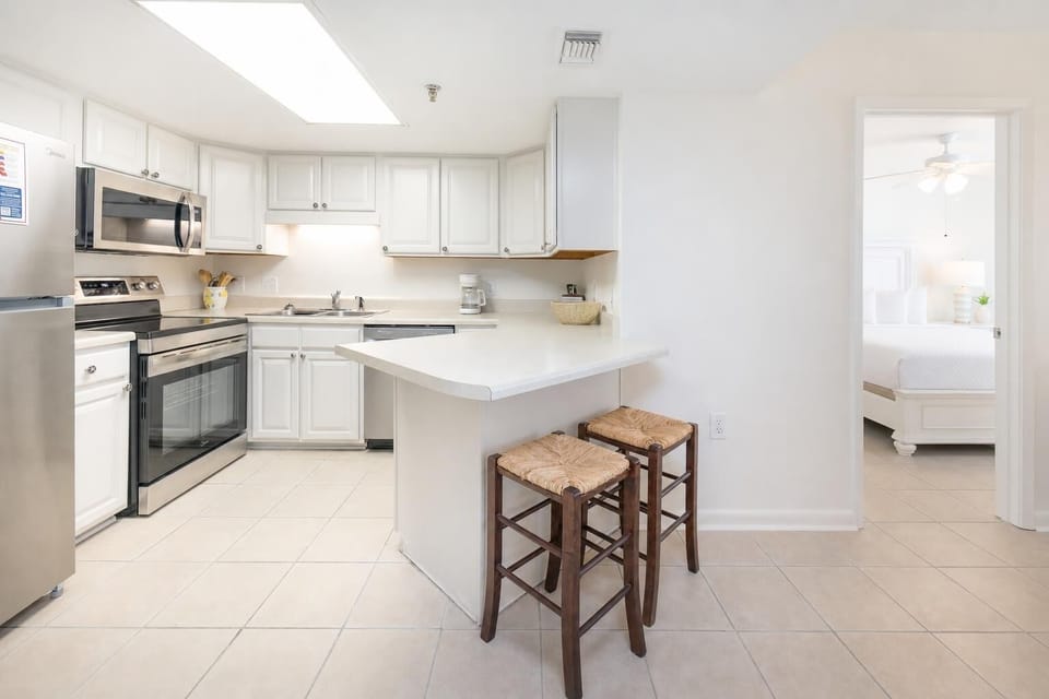 Bright kitchen welcomes you to prepare fresh meals while kids chat at the breakfast bar