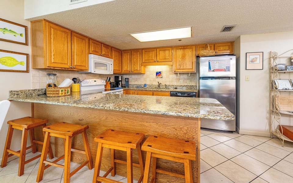 Kitchen featuring wooden cabinetry, granite countertops, and a breakfast bar with seating for a casual dining experience