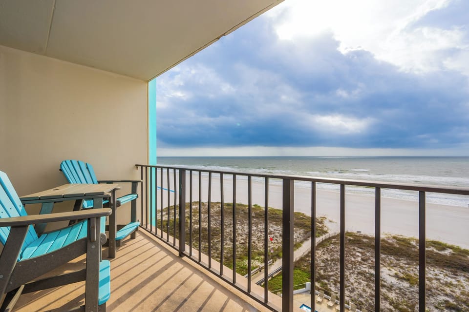 Relax on the balcony with stunning beach views, featuring comfortable seating for enjoying the coastal scenery