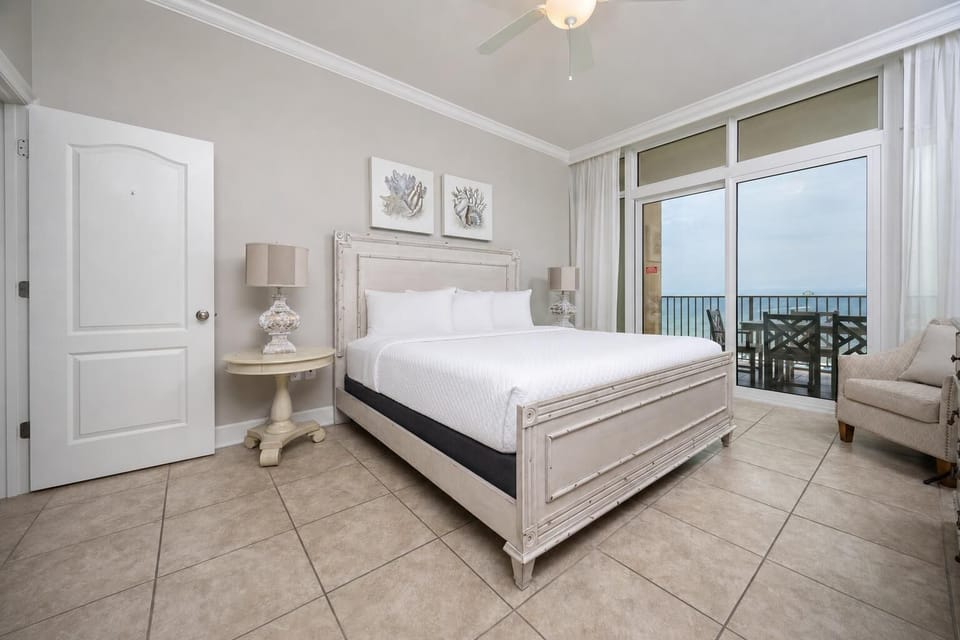Relax in the serene master bedroom featuring a king bed, stylish decor, and beachfront balcony access