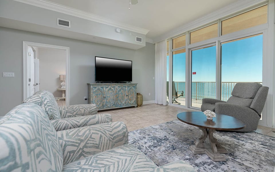 Unwind in the spacious living area, featuring comfortable seating and beachfront balcony access