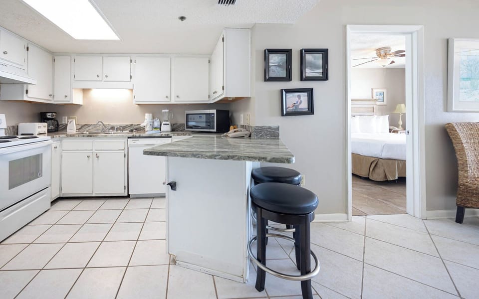 Prepare meals in this kitchen featuring a spacious counter and bar seating, with a beach view