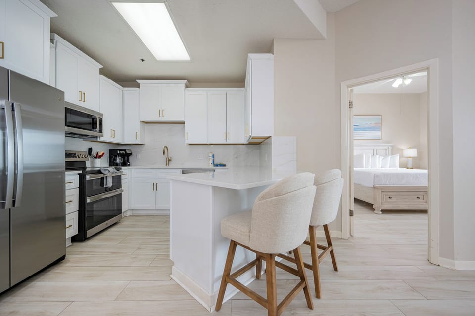 Soft light fills the kitchen as you settle into cushioned stools at the breakfast bar with your favorite drink