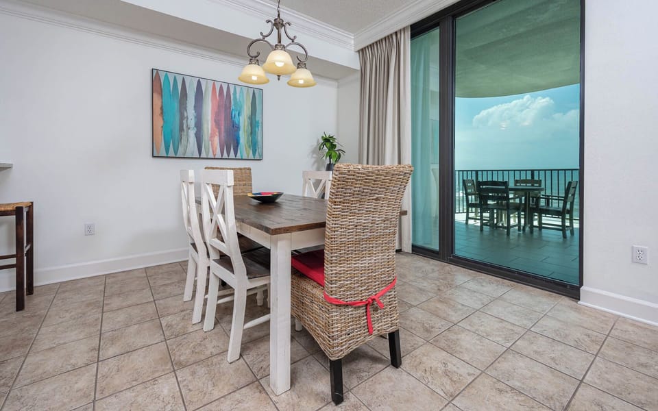 Gather around the rustic dining table, with stylish chairs and a view of the inviting outdoor space