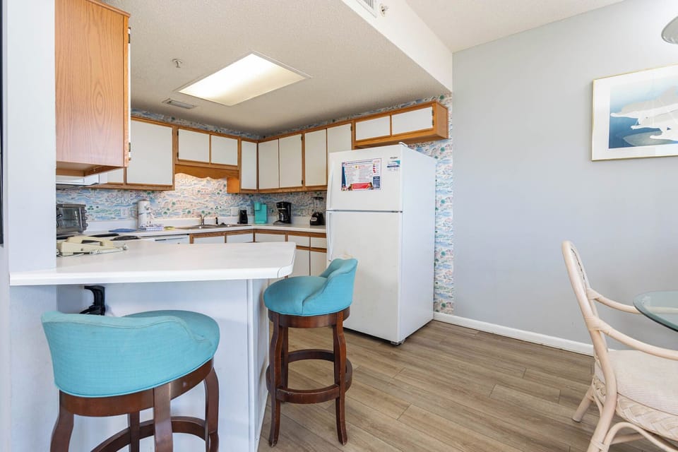 Cook and gather at the breakfast bar with colorful decor and a cozy dining area for shared meals and laughter
