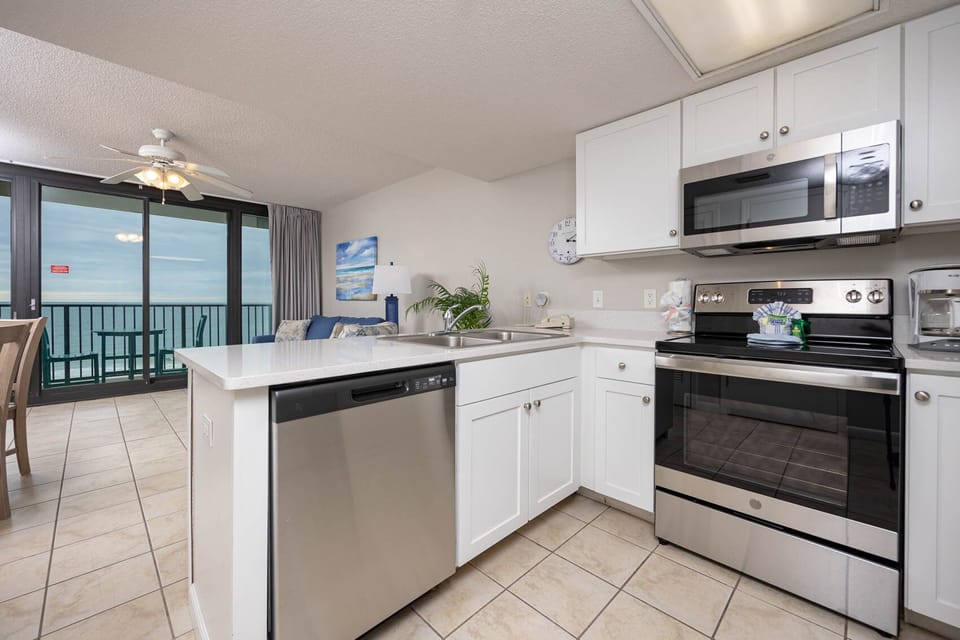 Enjoy cooking in this bright kitchen with modern appliances and a beachfront balcony view