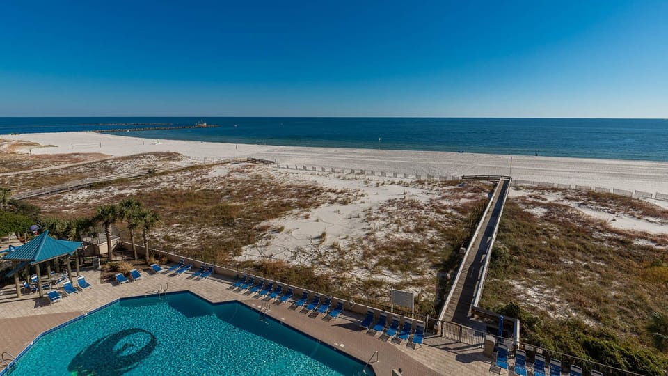 Enjoy the inviting poolside area with lounge chairs, perfect for soaking up the sun and relaxing by the water