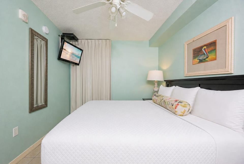 Fluffy pillows invite you to relax in the king suite for a calm movie night after a fun day at the beach