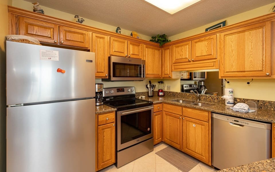 The kitchen features warm wood cabinetry, granite countertops, and a convenient breakfast bar for entertaining