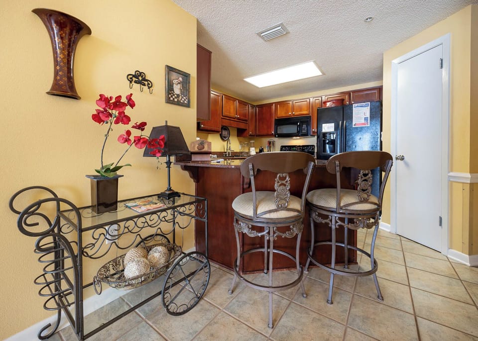 Relax at the stylish bar seating while enjoying the view of the inviting kitchen and its warm decor