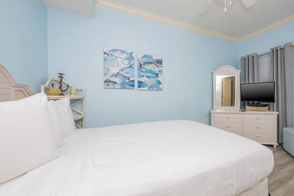 Experience blissful sleep in a serene guest bedroom with soft queen bedding and a TV for your favorite shows