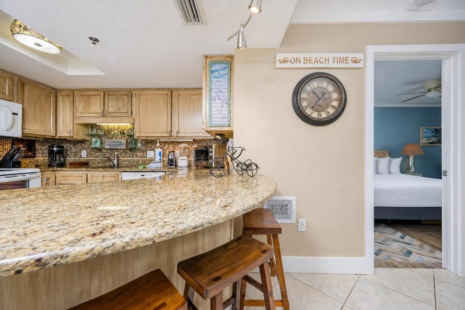 Breakfast bar and granite countertops complement the warm-toned cabinetry in this inviting kitchen space