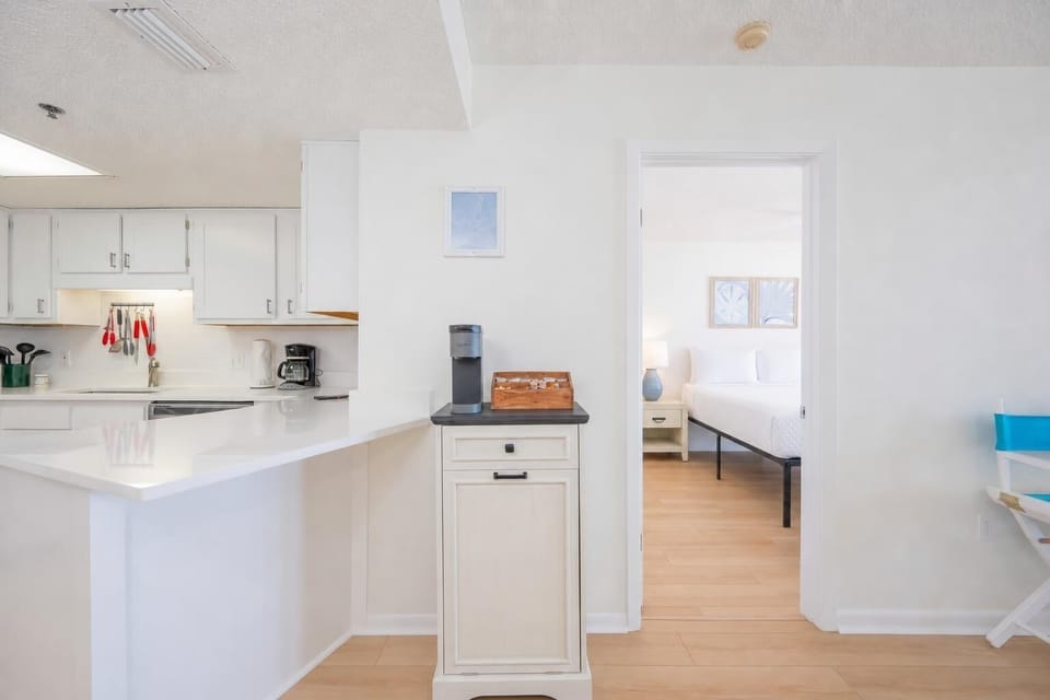 Bright kitchen features a breakfast bar with yellow stools, stainless appliances, and artistic wall decor for a cheerful vibe
