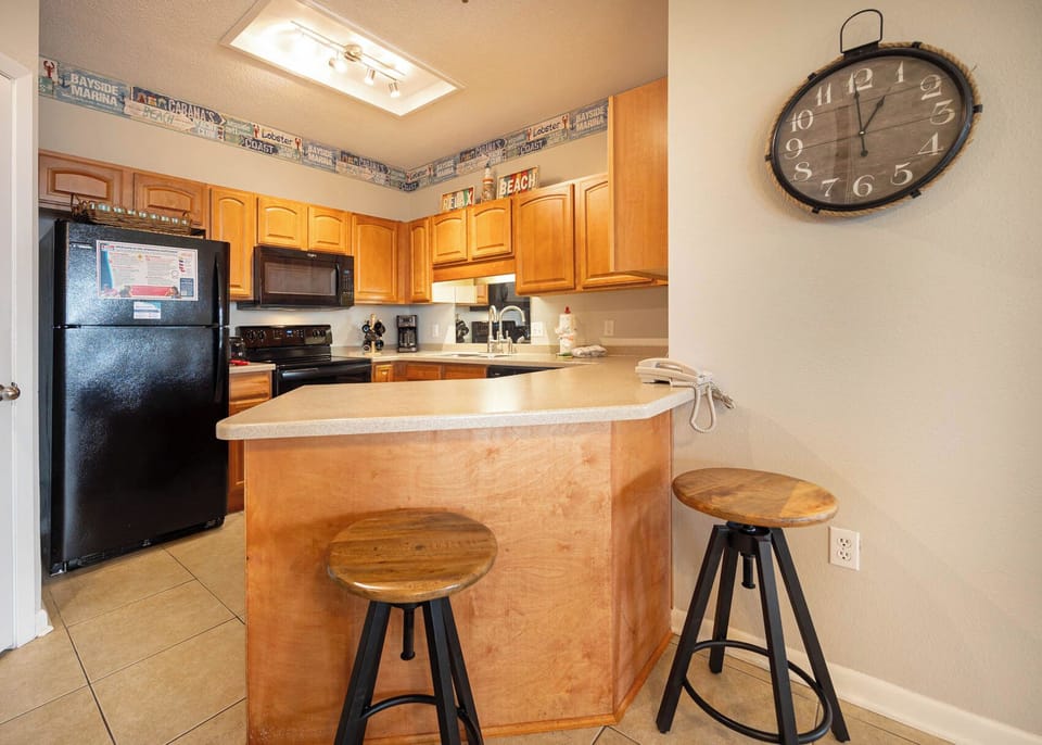 Gather around the inviting kitchen bar with wooden stools, perfect for casual meals and conversation