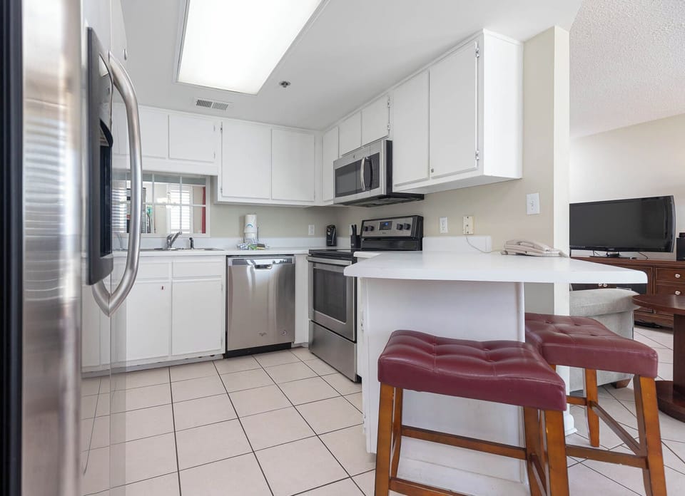 Prepare meals in the bright kitchen featuring stainless appliances and a breakfast bar