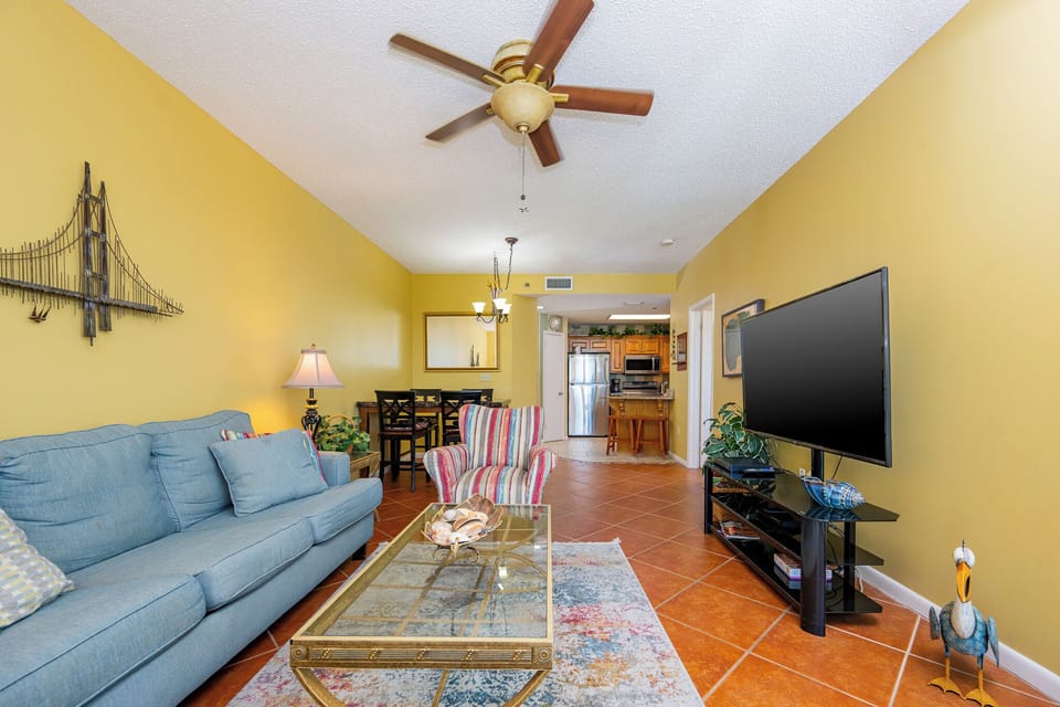 Unwind in the inviting living area featuring a cozy couch with queen sleeper, vibrant decor, and a large TV