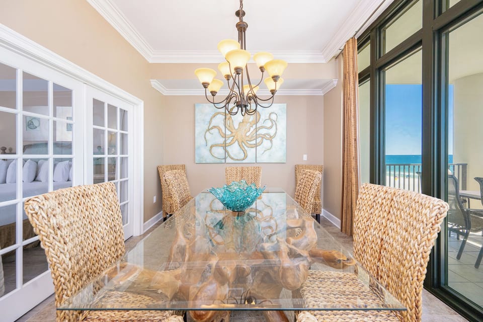 Embrace coastal charm as you gather around the glass dining table, soaking in vibrant views and cheerful decor
