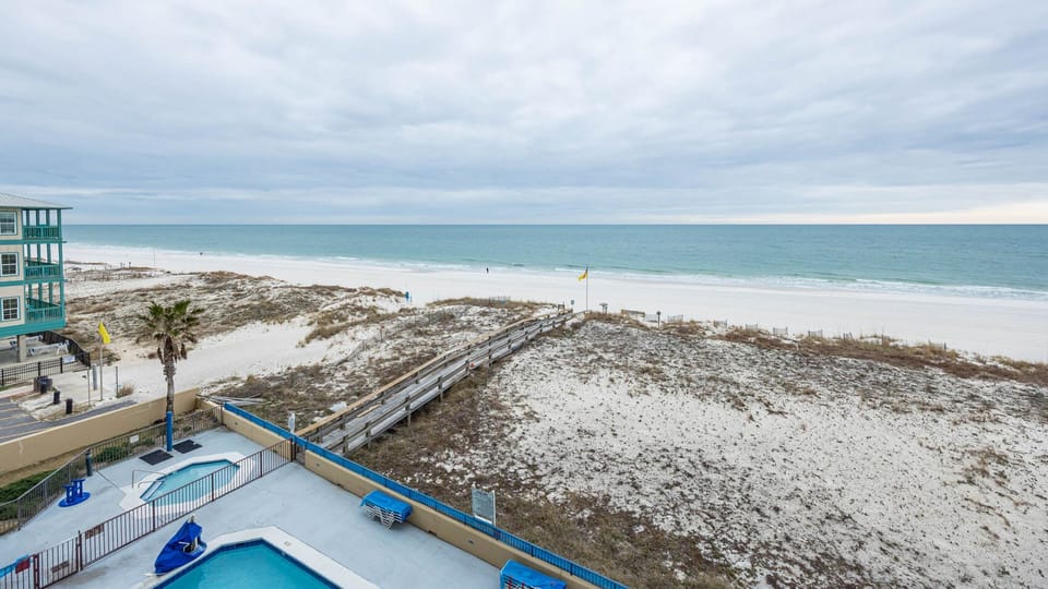 Gaze at the tranquil water and beach from your beachfront balcony, perfect for relaxation and enjoying the view