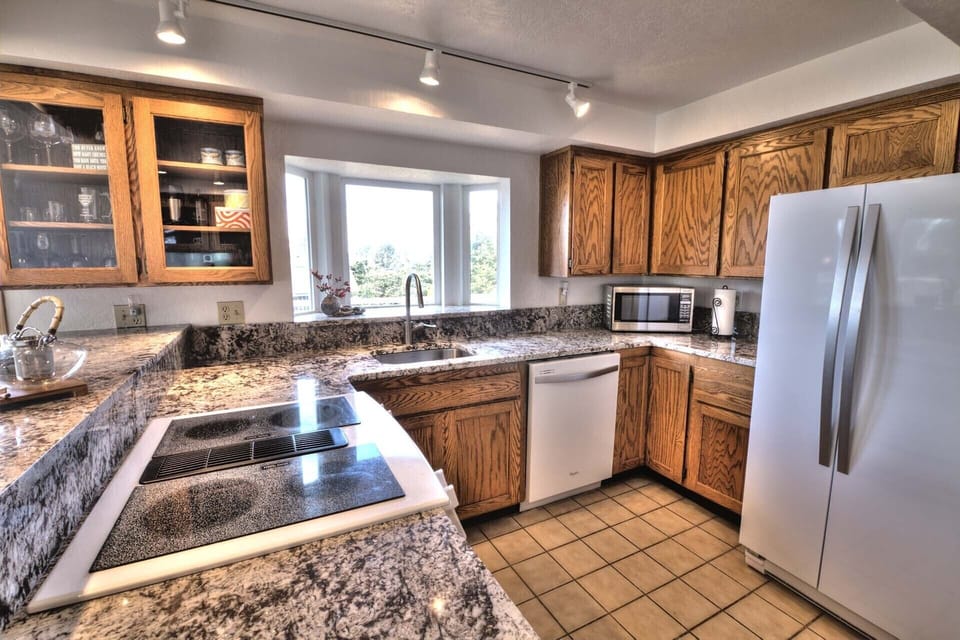 Granite counter-tops, and see through cabinetry highlight this stylish kitchen.