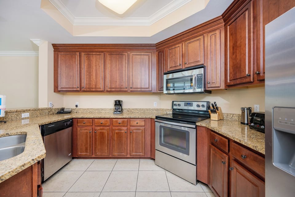Modern kitchen featuring stainless appliances, rich wood cabinetry, and granite countertops for a stylish cooking experience