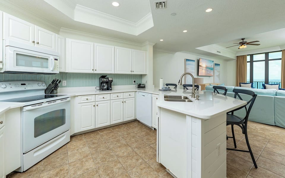 Bright kitchen with breakfast bar seating invites you to prepare snacks while catching gulf views nearby