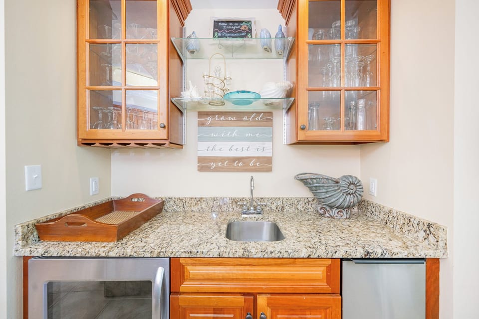 Mix drinks or refresh with snacks at your elegant wet bar with a stylish glassware display, wine cooler, and ice maker